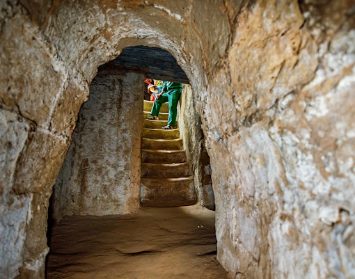 Stairs inside Cu Chi Tunnels with a guide leading a private tour.