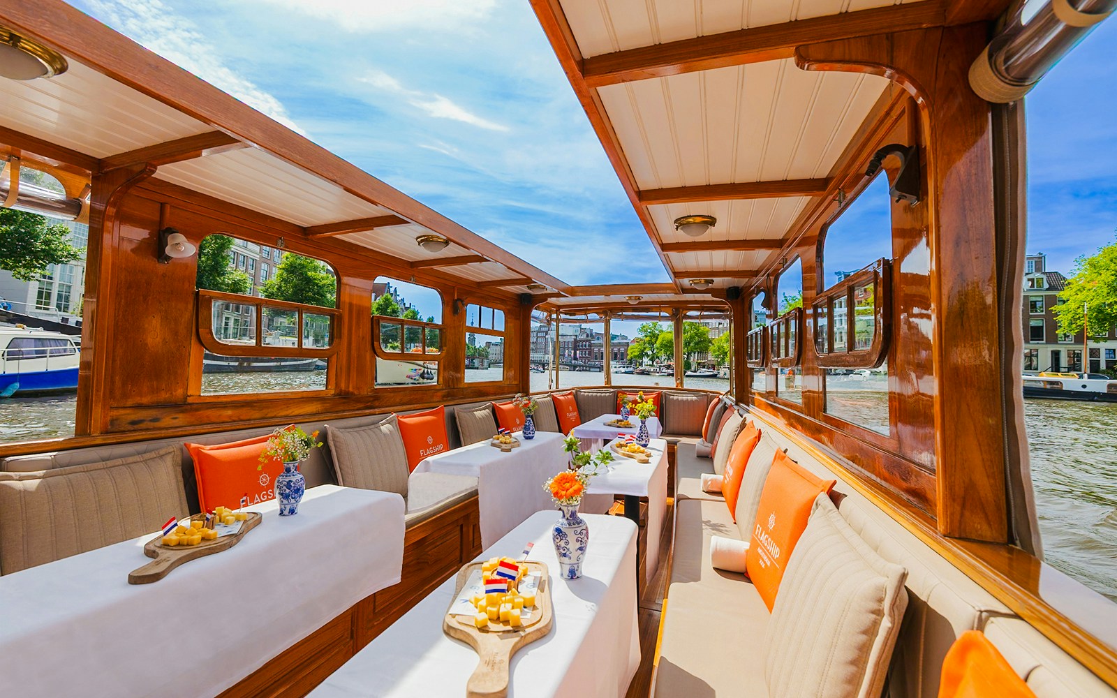 Interiors of a canal cruise boat in Amsterdam with tables set for dining.