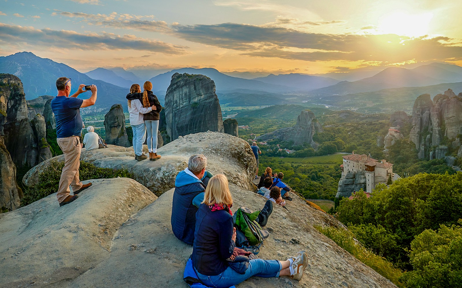 Visitor admiring Meteora rock formations from a viewpoint in Greece.