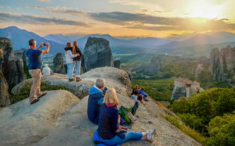 Visitor admiring Meteora rock formations from a viewpoint in Greece.