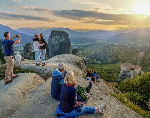 Visitor admiring Meteora rock formations from a viewpoint in Greece.