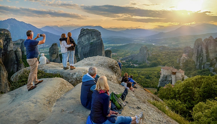 Visitor admiring Meteora rock formations from a viewpoint in Greece.