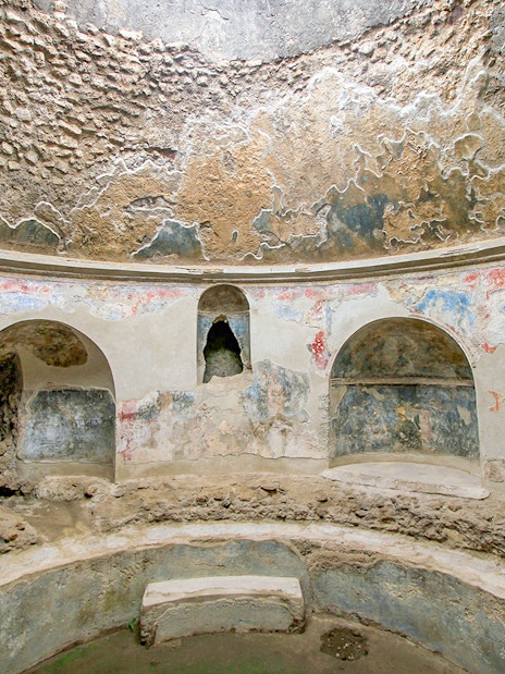 Stabian Baths in Pompeii with ancient frescoes and stone seating.