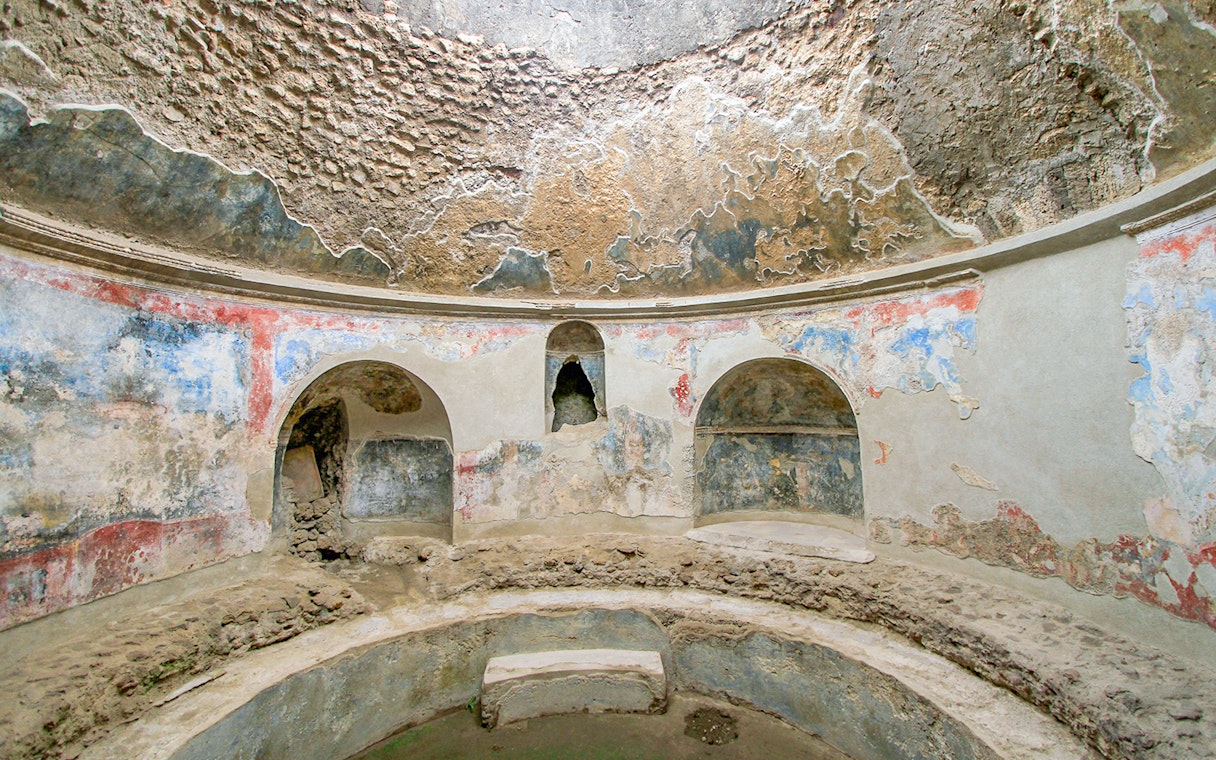Stabian Baths in Pompeii with ancient frescoes and stone seating.