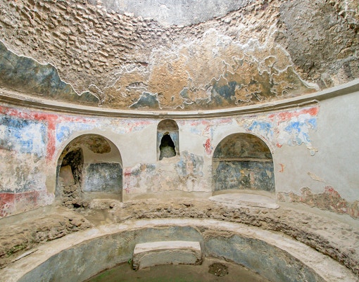 Stabian Baths in Pompeii with ancient frescoes and stone seating.
