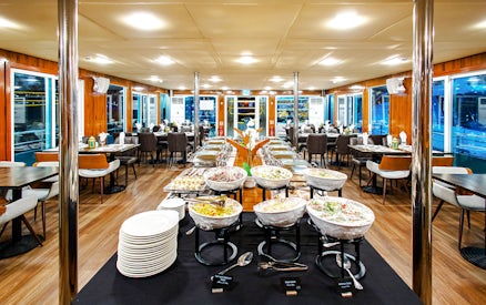 Dining setup on Alexandra Sea Lounge Dhow Cruise with buffet and seating area.
