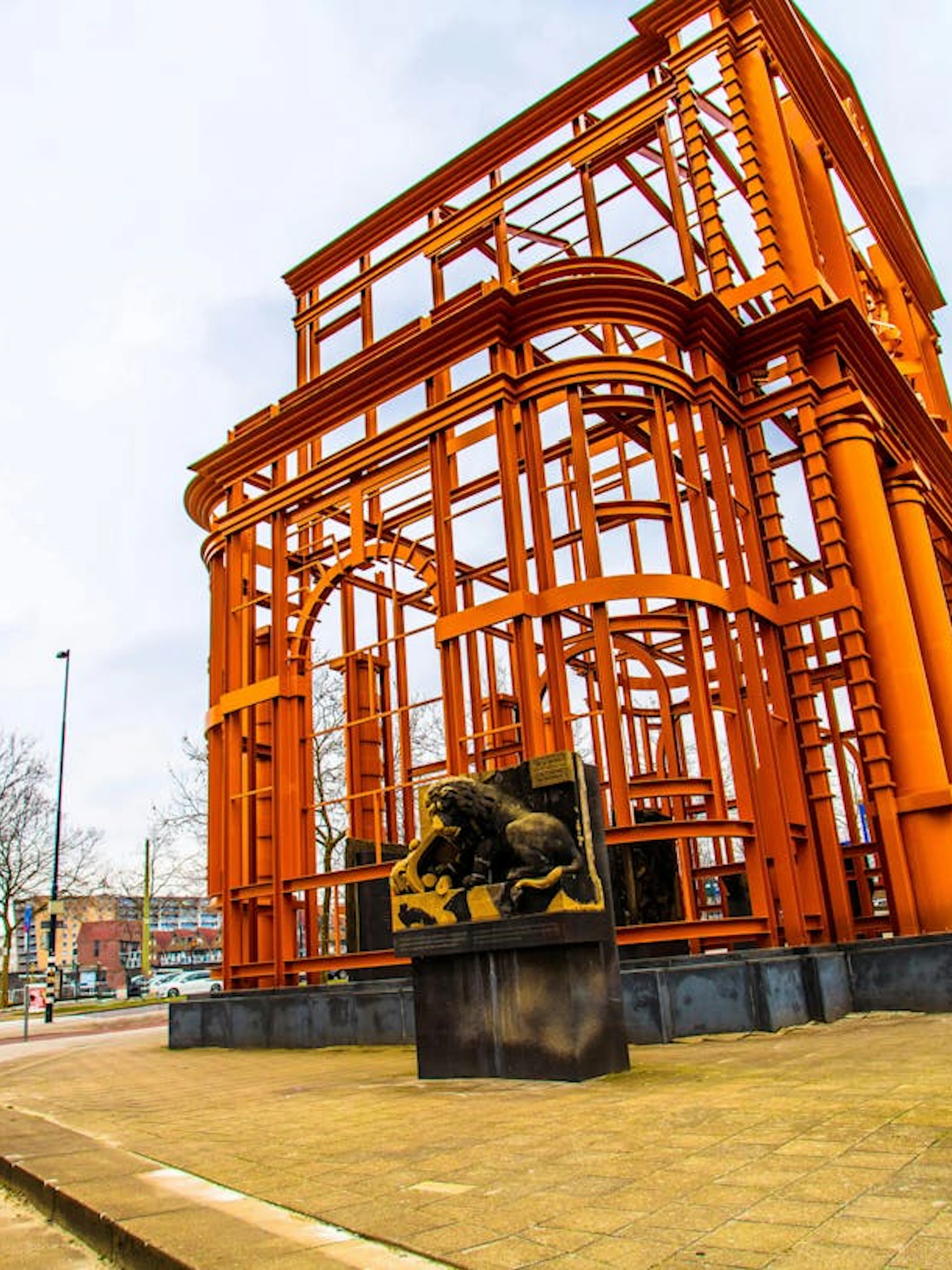 Orange steel structure with lion statues in Rotterdam, part of the Spy Hunt city exploration game.