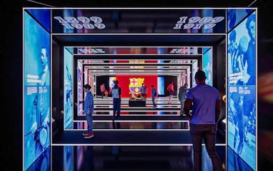 FC Barcelona museum exhibit with historical displays and visitors exploring.