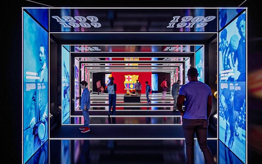 FC Barcelona museum exhibit with historical displays and visitors exploring.