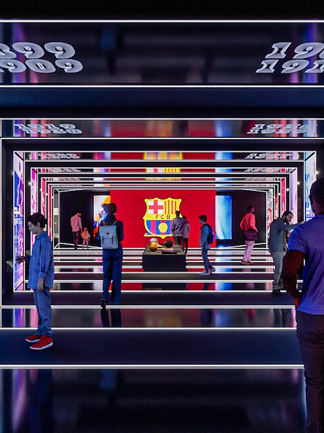FC Barcelona museum exhibit with historical displays and visitors exploring.