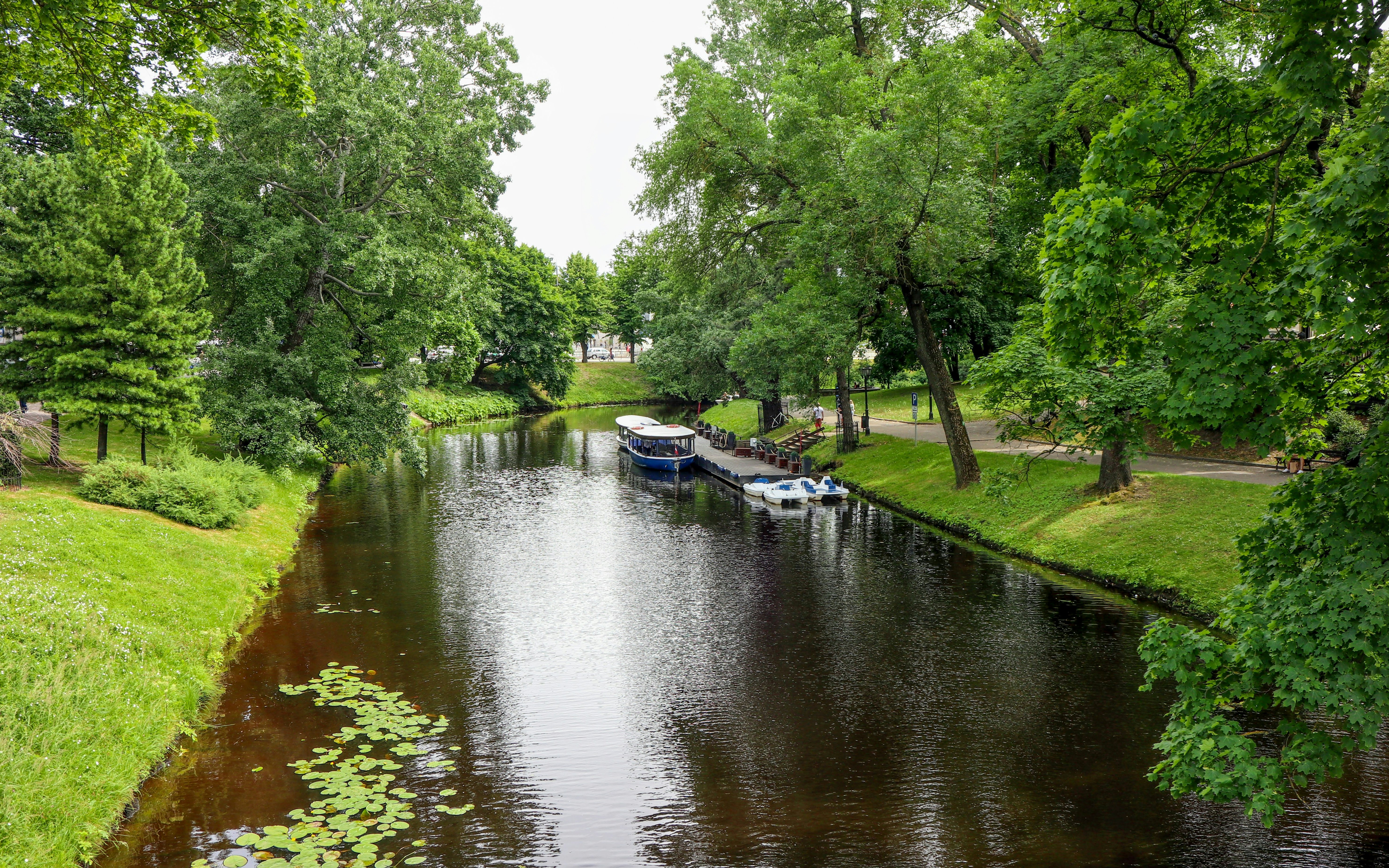 Boat docked along Degerö Canal surrounded by lush greenery.