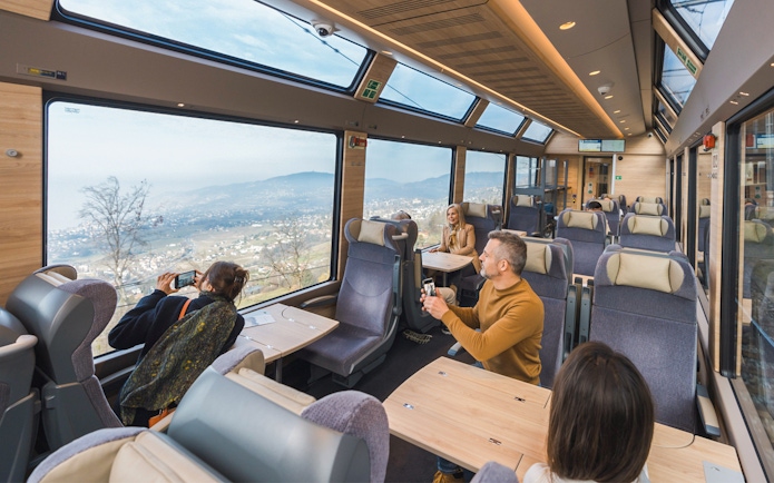 Passengers enjoying panoramic views on the GoldenPass Express train from Montreux to Interlaken.