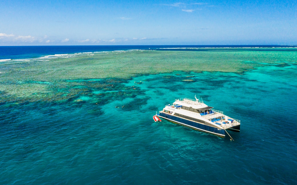 Cruise ship anchored at Great Barrier Reef with clear blue waters.