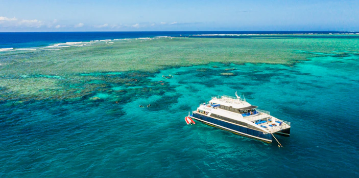 Cruise ship anchored at Great Barrier Reef with clear blue waters.