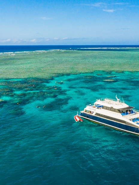 Cruise ship anchored at Great Barrier Reef with clear blue waters.