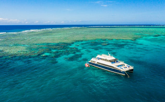 Cruise ship anchored at Great Barrier Reef with clear blue waters.