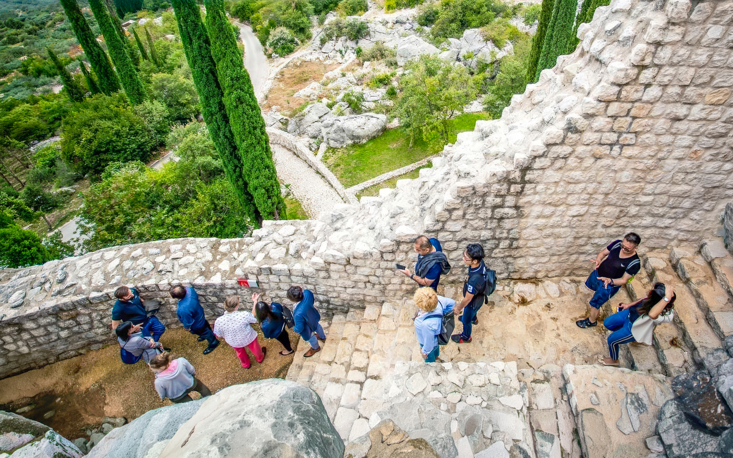 Tour group exploring ancient stone walls at Skol Grad, Croatia.