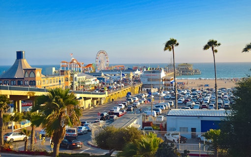 Santa Monica Pier with Ferris wheel, beachgoers, and ocean view in Los Angeles.