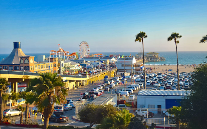 Santa Monica Pier with Ferris wheel, beachgoers, and ocean view in Los Angeles.