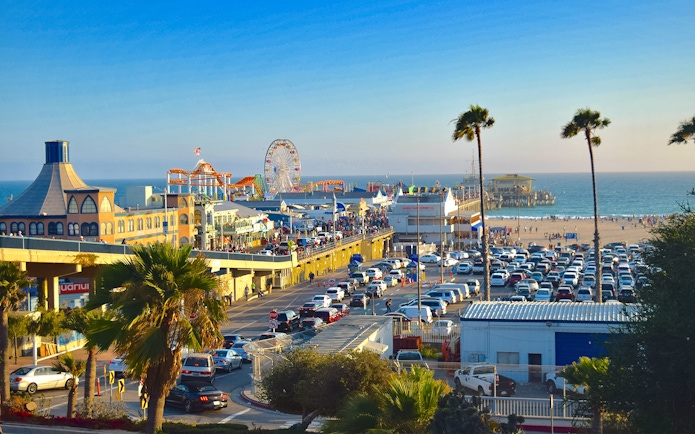 Santa Monica Pier with Ferris wheel, beachgoers, and ocean view in Los Angeles.