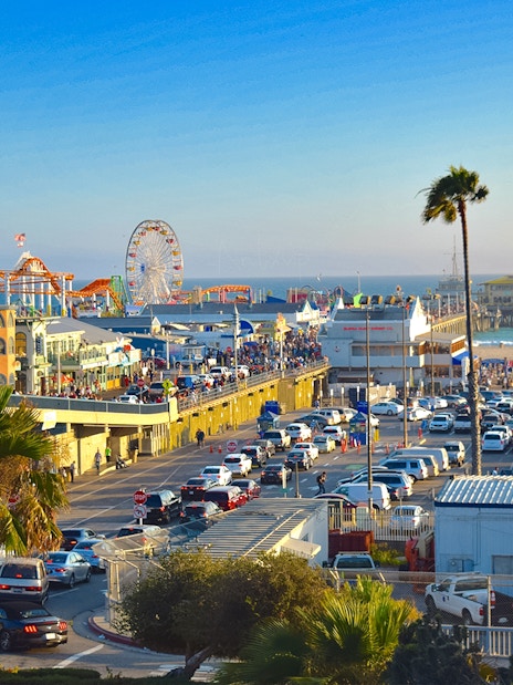 Santa Monica Pier with Ferris wheel, beachgoers, and ocean view in Los Angeles.