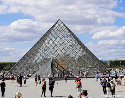 Crowds gather around the Glass Pyramid at the Louvre Museum in Paris.