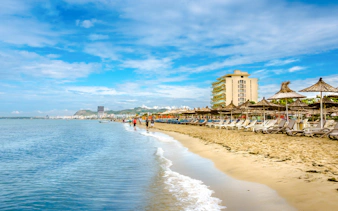 Beachfront with sun loungers and umbrellas along the shoreline in Albania.