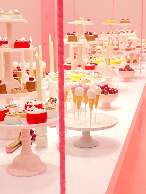 Five ice cream stations with diverse flavors in a vibrant pink market setting.