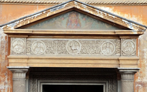 Basilica of Santa Pudenziana entrance with detailed stone carvings and religious symbols.