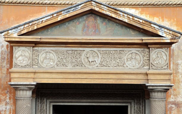 Basilica of Santa Pudenziana entrance with detailed stone carvings and religious symbols.