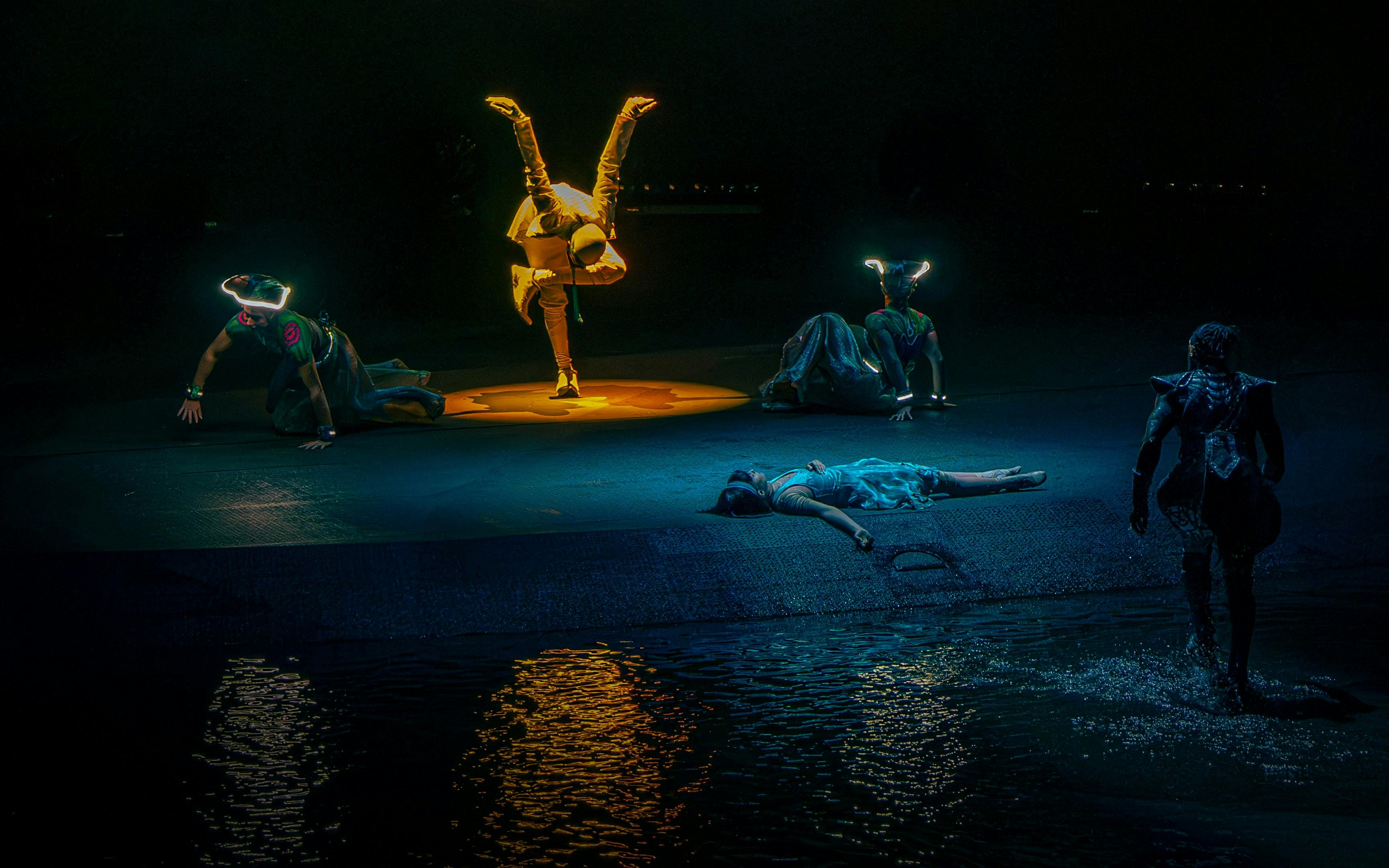 Performers in illuminated costumes during La Perle's "Pearl's Death" scene in Dubai.