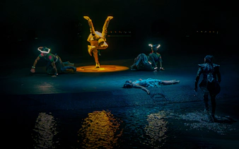 Performers in illuminated costumes during La Perle's "Pearl's Death" scene in Dubai.