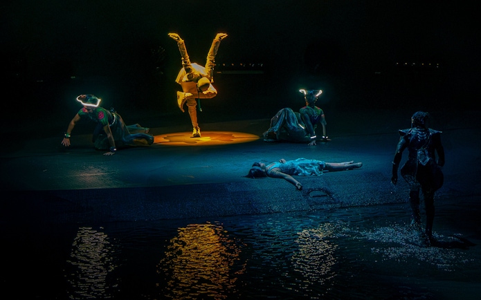 Performers in illuminated costumes during La Perle's "Pearl's Death" scene in Dubai.