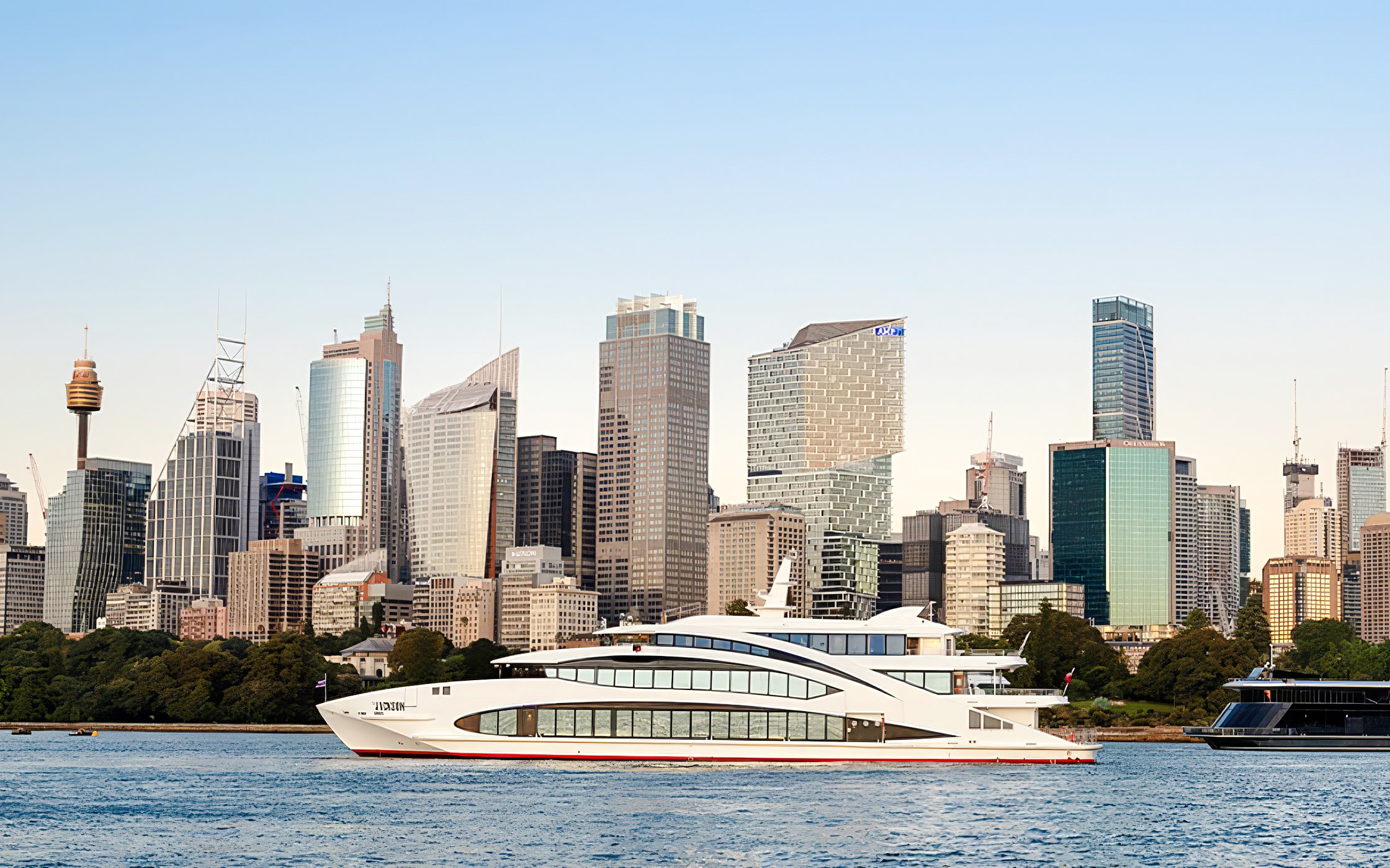 Luxury yacht The Jackson cruising in Sydney Harbour with city skyline backdrop.