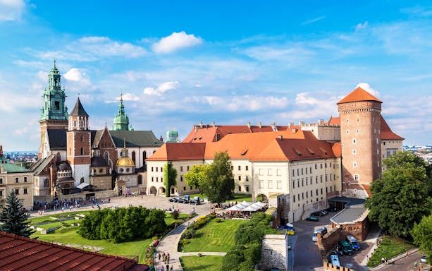 Wawel Castle and Cathedral in Krakow, Poland, with tourists exploring the grounds.