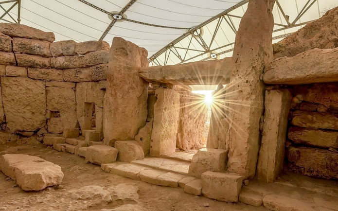 Hagar Qim Temples interior with sunlight streaming through ancient limestone structures.
