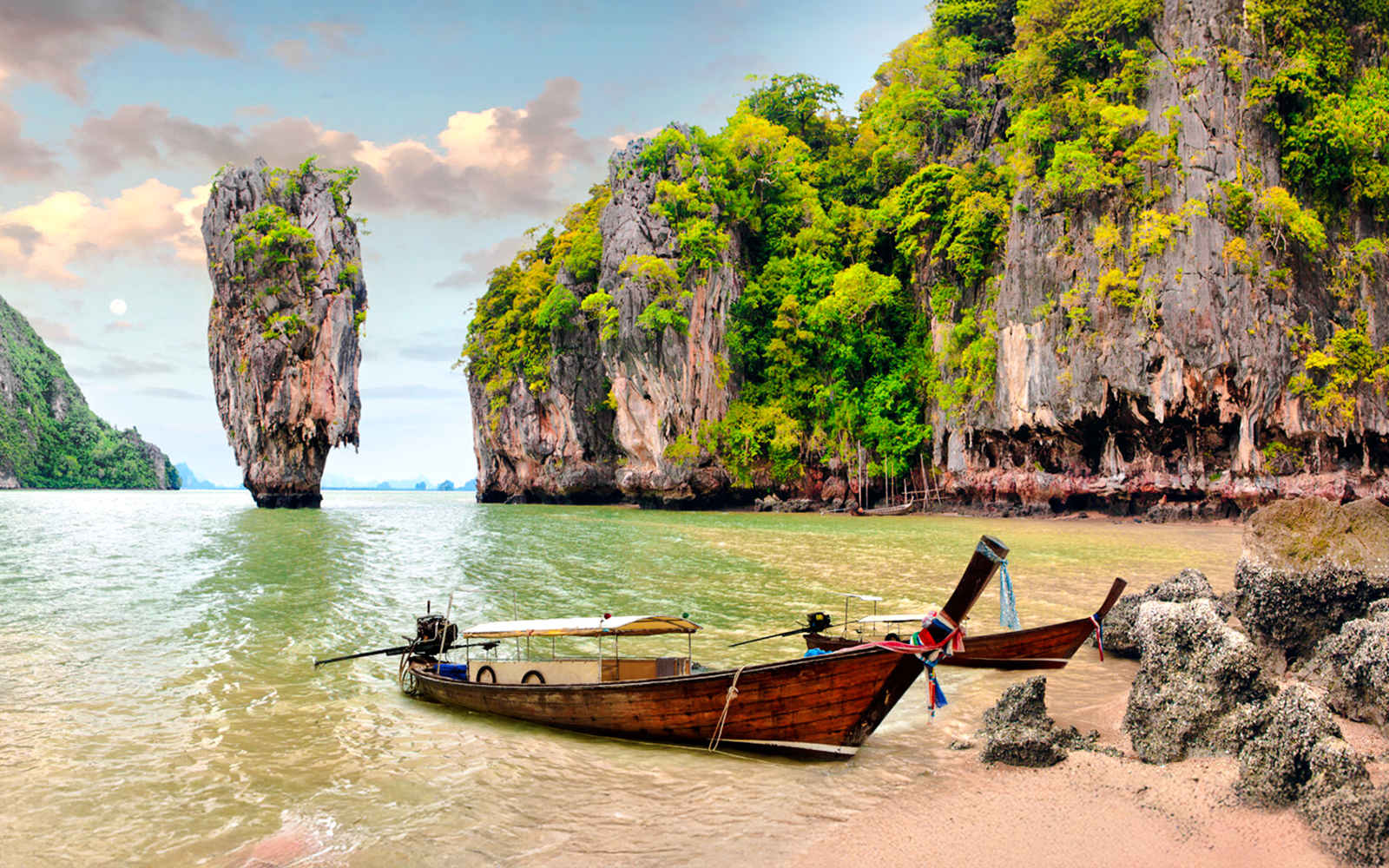Longtail boats near limestone cliffs at James Bond Island, Thailand.