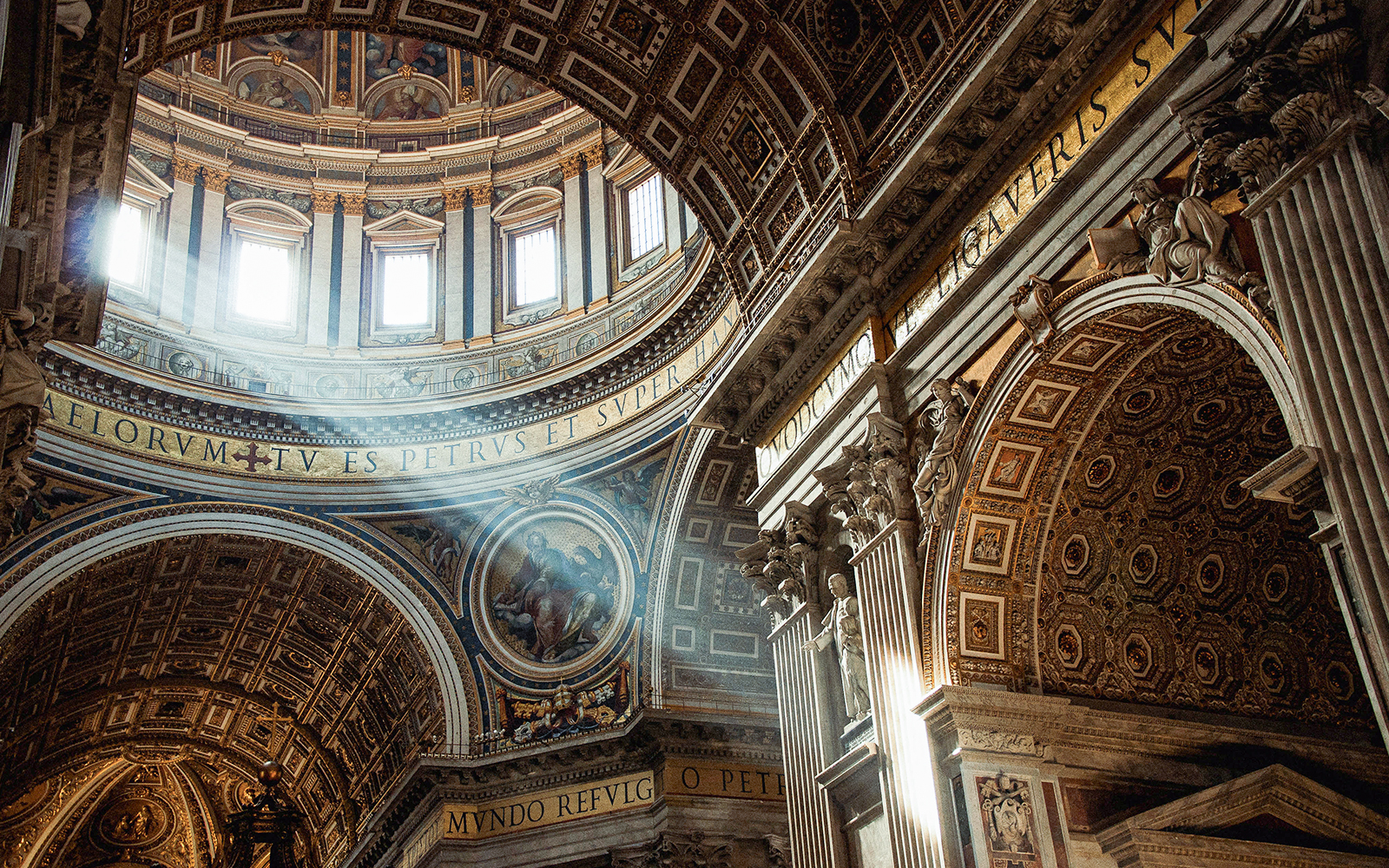 St. Peter’s Basilica interior with ornate ceiling and sunlight streaming through windows.