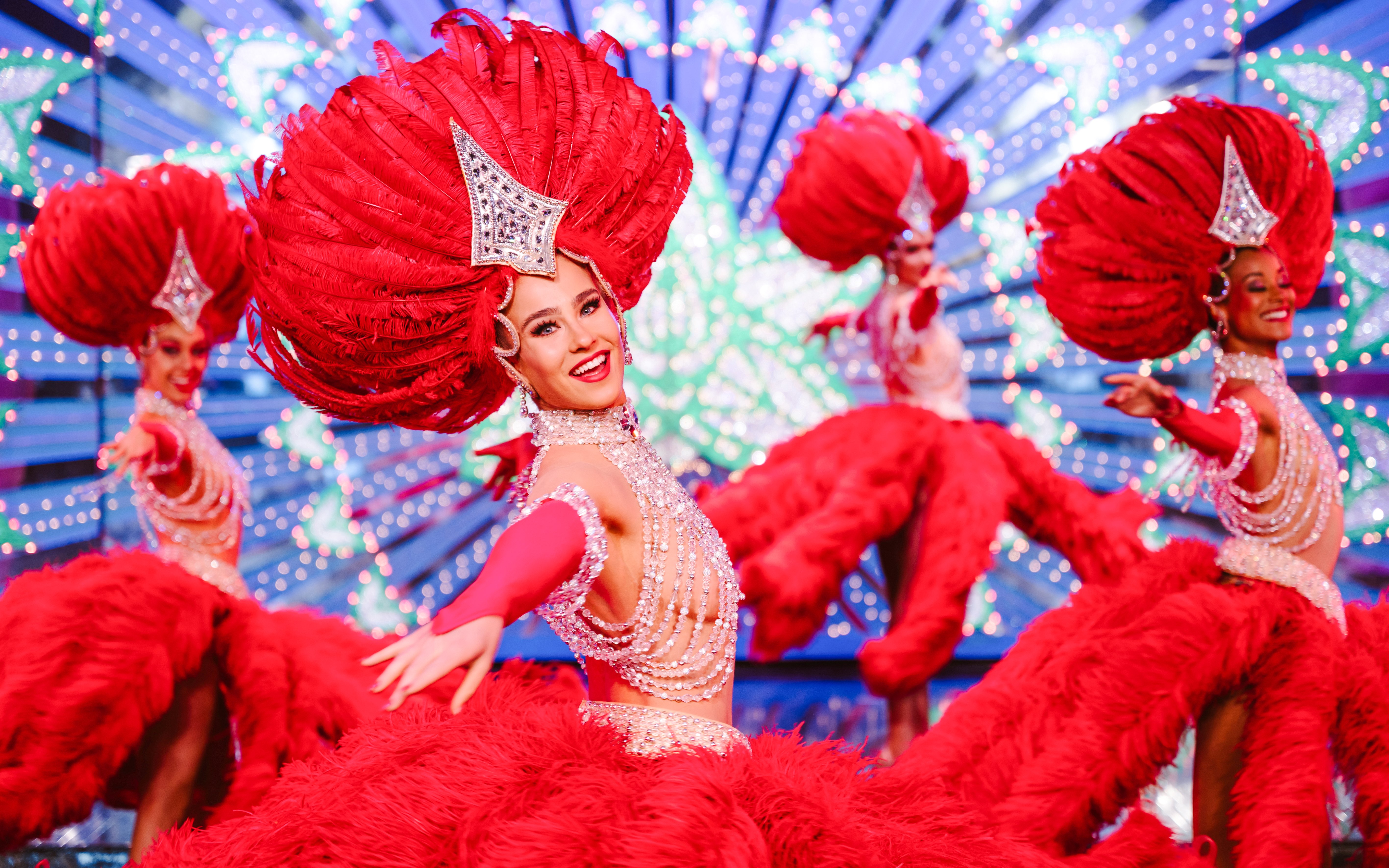 Performers in vibrant red costumes at the Moulin Rouge Show, Paris.