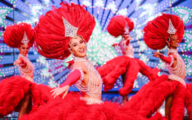 Performers in vibrant red costumes at the Moulin Rouge Show, Paris.