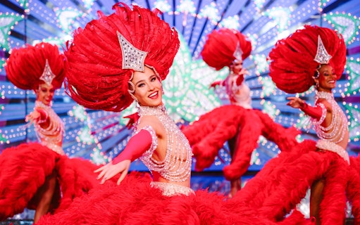 Performers in vibrant red costumes at the Moulin Rouge Show, Paris.
