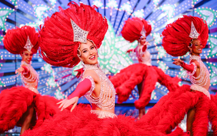 Performers in vibrant red costumes at the Moulin Rouge Show, Paris.