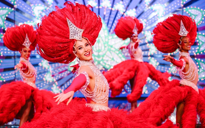 Performers in vibrant red costumes at the Moulin Rouge Show, Paris.