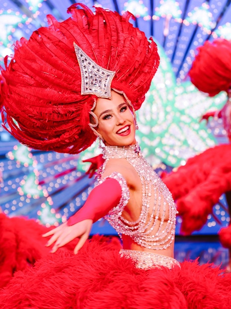 Performers in vibrant red costumes at the Moulin Rouge Show, Paris.
