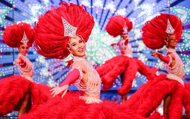 Performers in vibrant red costumes at the Moulin Rouge Show, Paris.