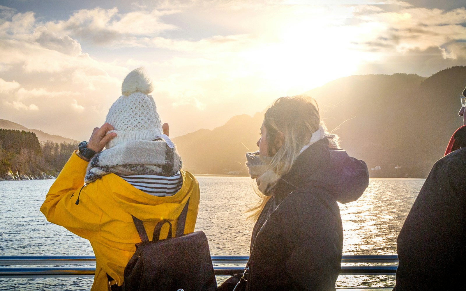 People enjoying the Mostraumen Fjord Cruise from Bergen, with scenic mountain views.