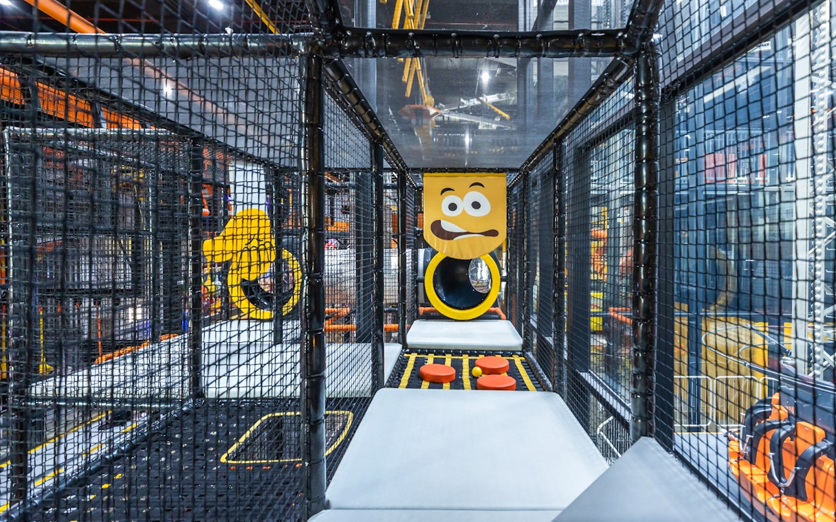 Indoor play area with climbing structures and slides at Adrenark Adventure.