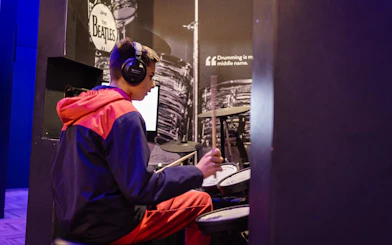 Person playing drums at The British Music Experience exhibit.
