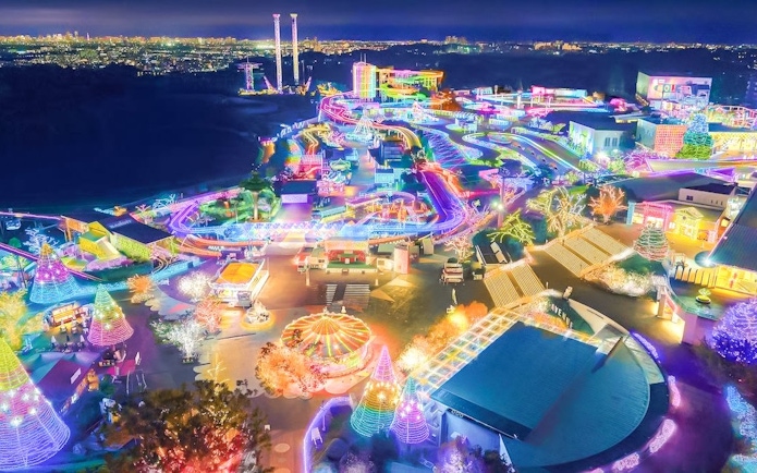 Night view of Yomiuriland amusement park illuminated with colorful lights in Tokyo, Japan.