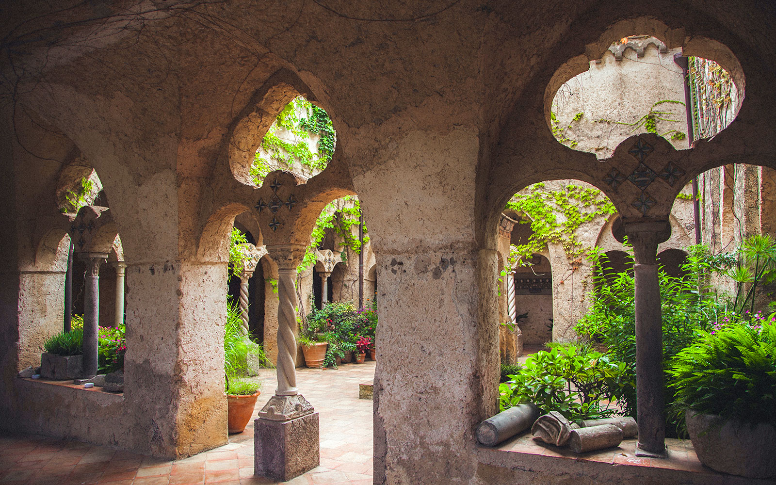 Medieval cloister with arches and greenery, Amalfi Coast.
